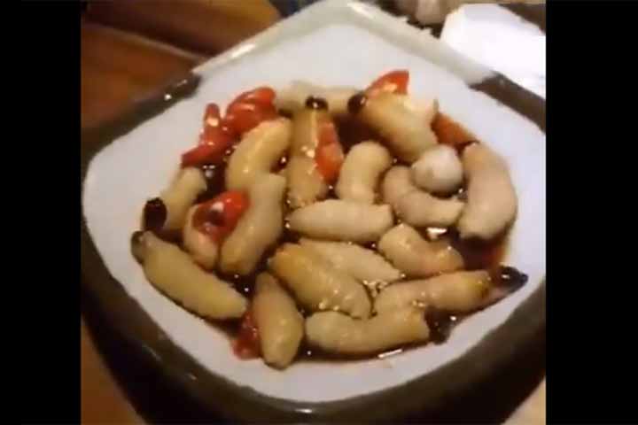 vietnam man eating wriggling worms in restaurant